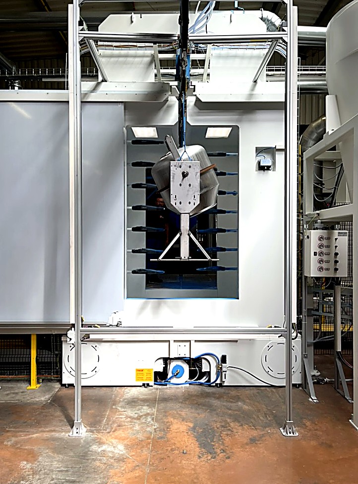 La cabine de poudrage automatique WAGNER, pistolets sur axes de part et d’autre du passage.